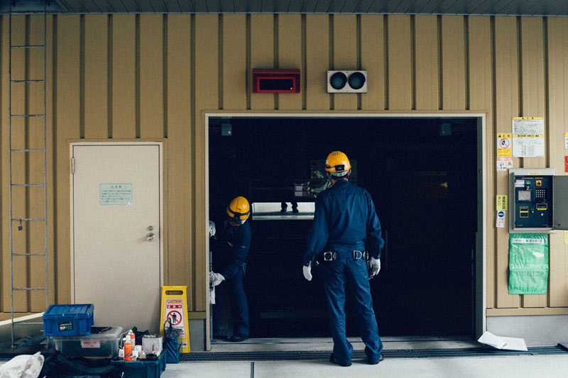 laborers in hard hat at entry to warehouse