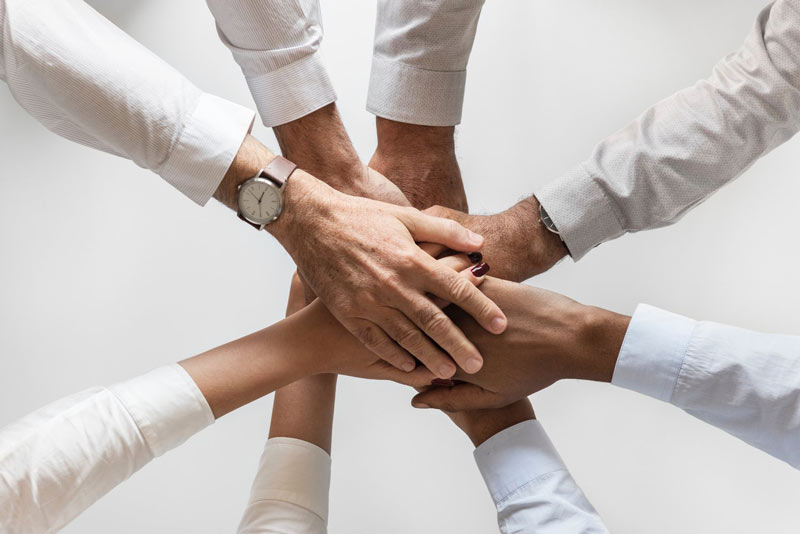 business people bring hands together